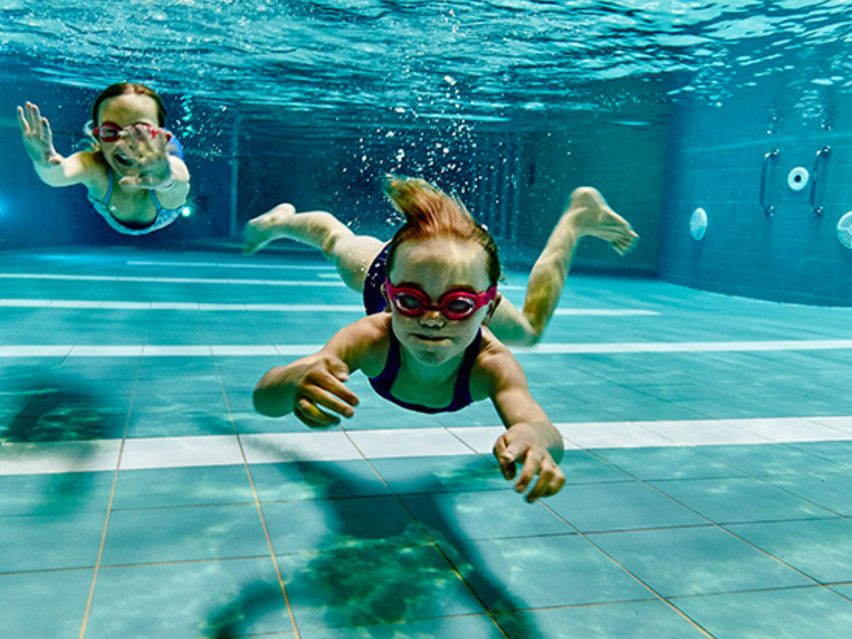 Foto van 2 kindjes zwemmend in een zwembad van Sportoase.